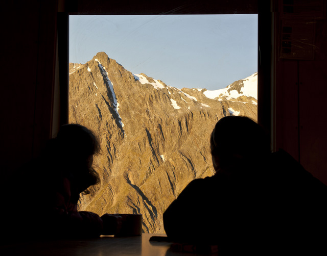 Photo: mountain view from hut with people silhouetted