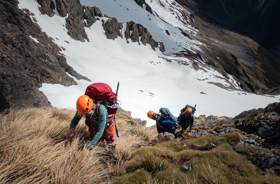 Scrambling up the snowgrass and rocky ledges of the zig-zag route