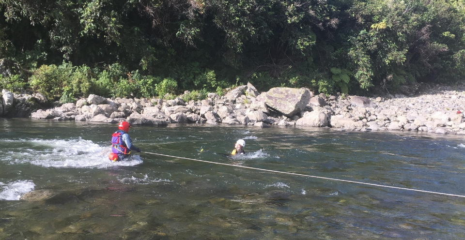 A person floats down the river about to hit the strainer