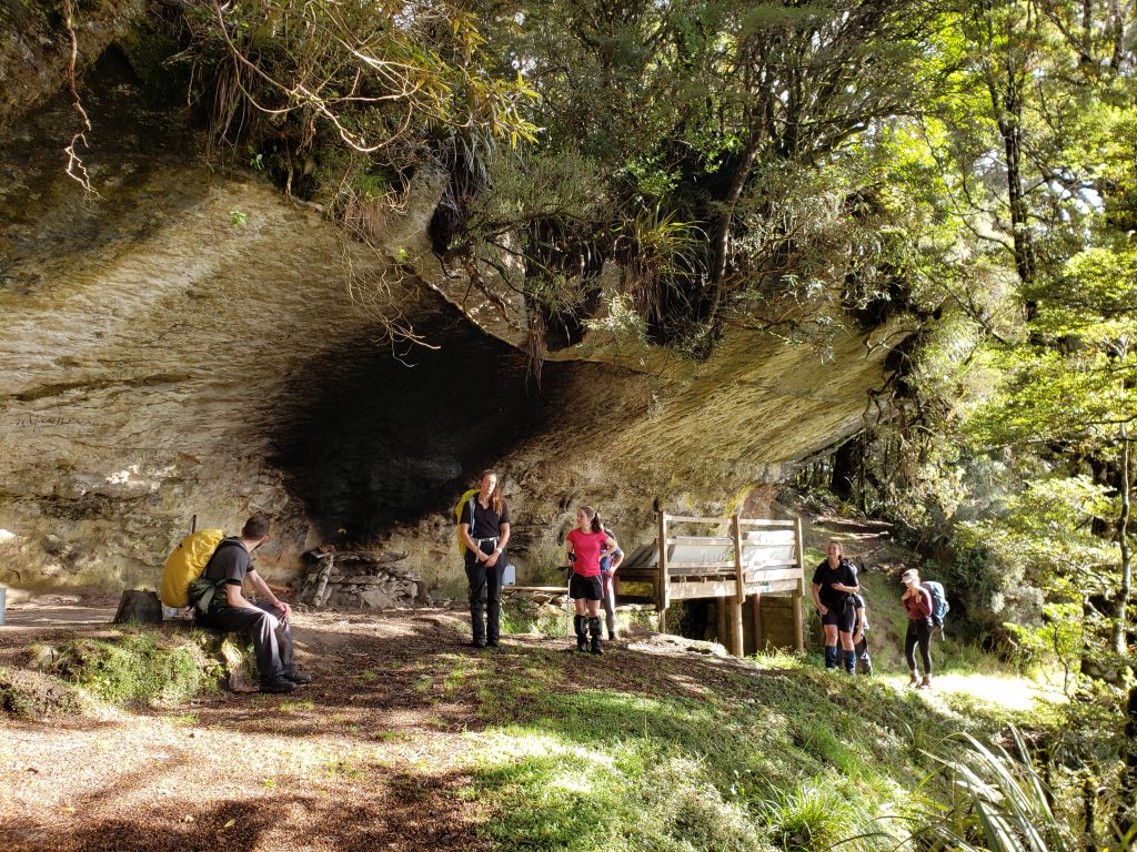 Trampers at a large rock shelter