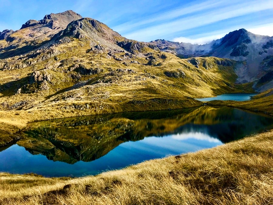 photo of an alpine lake and mountains behind