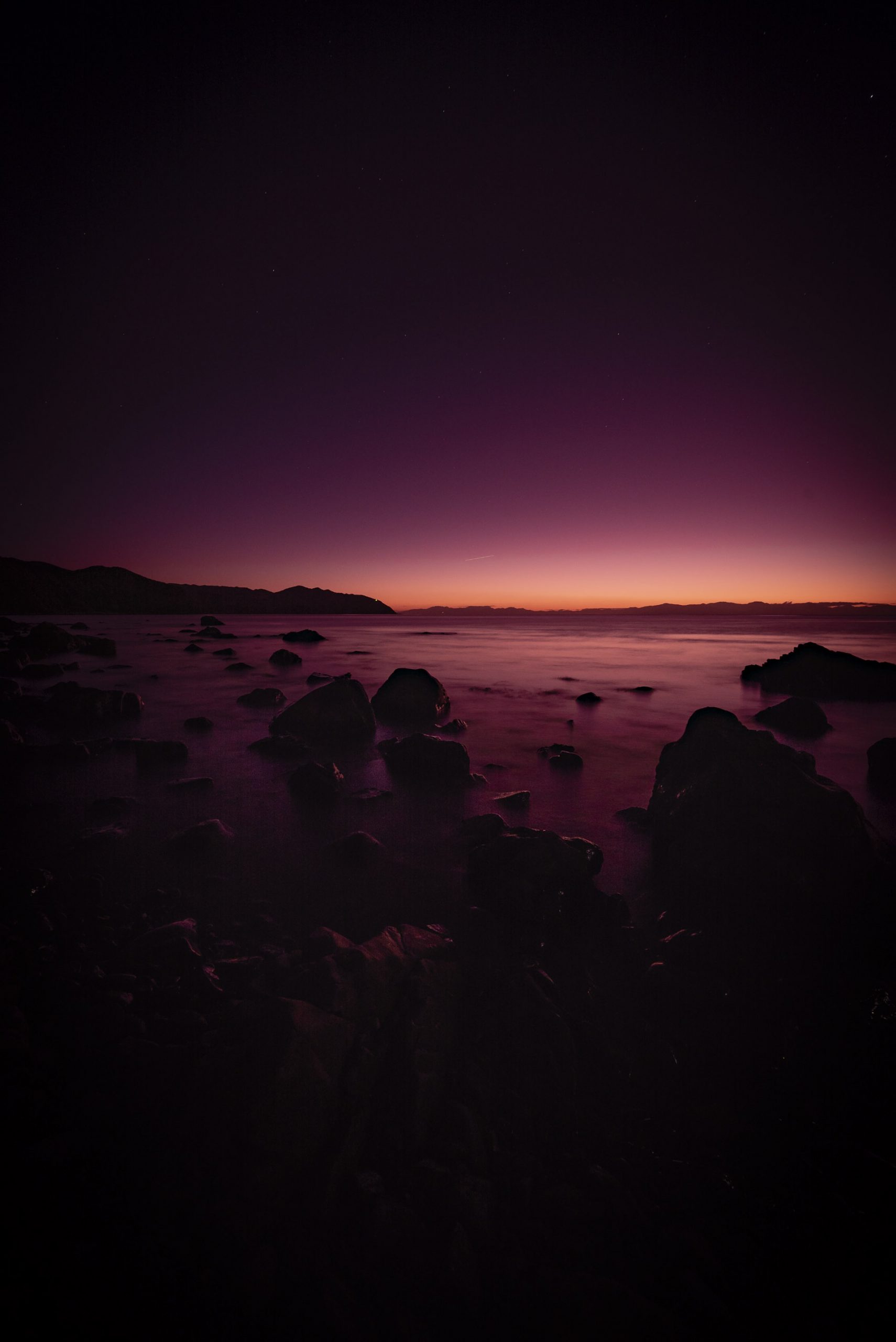 A purple haze hangs over the sea at twilight