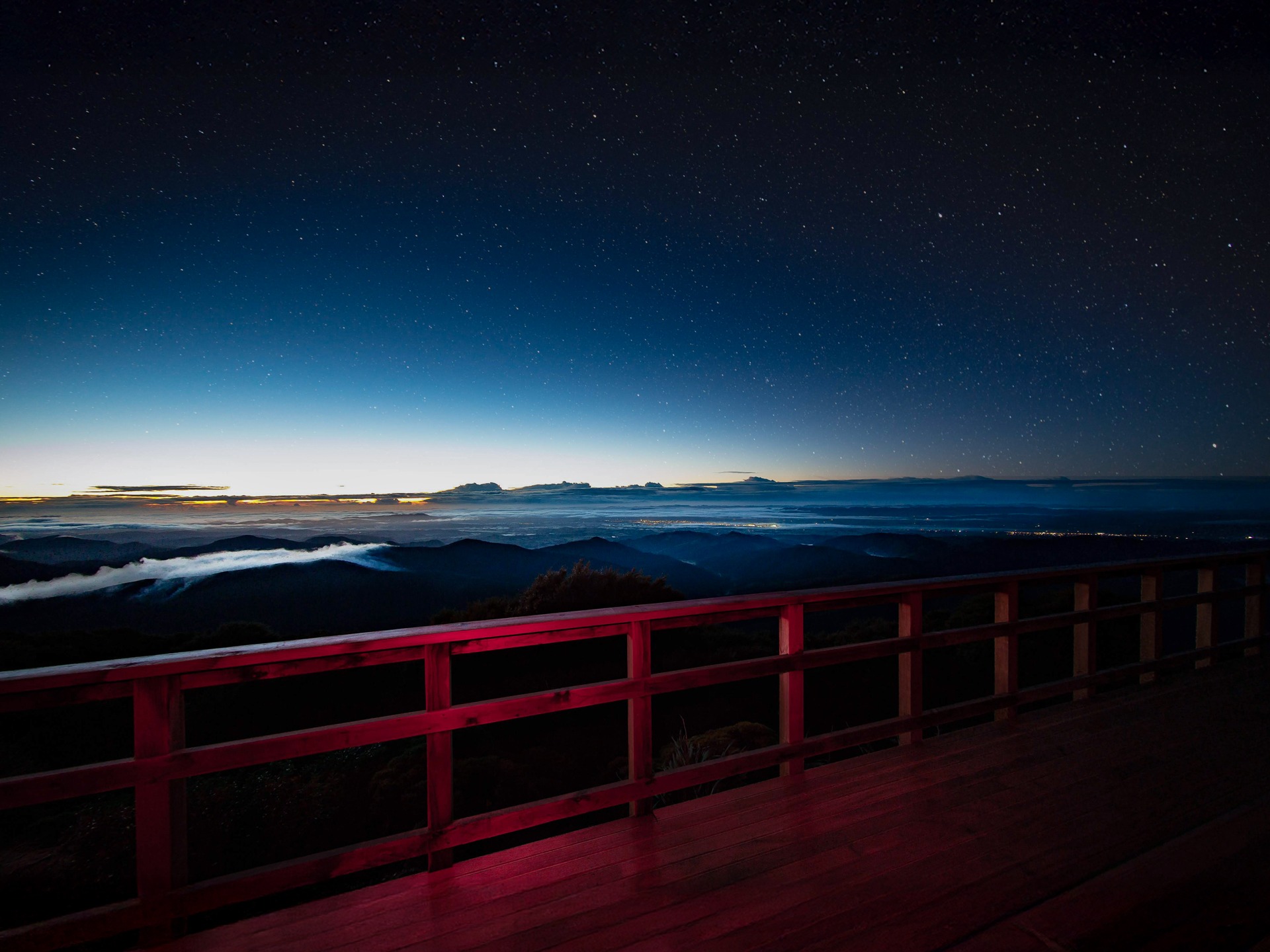 Powell Hut rebuild 2019 - dawn and the lights of the Wairarapa from the hut deck